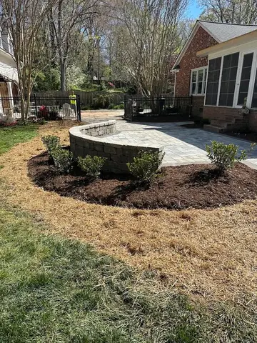 Curved stone wall with mulch and plants in Monroe, NC.