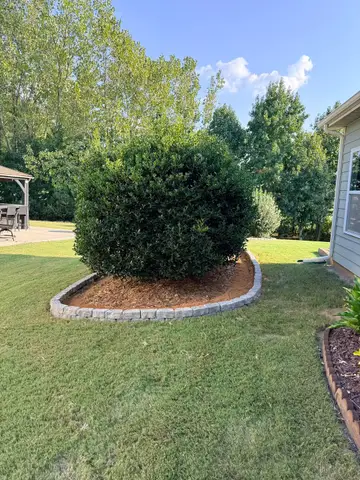Circular flower bed with shrubs and mulch in Monroe, NC.
